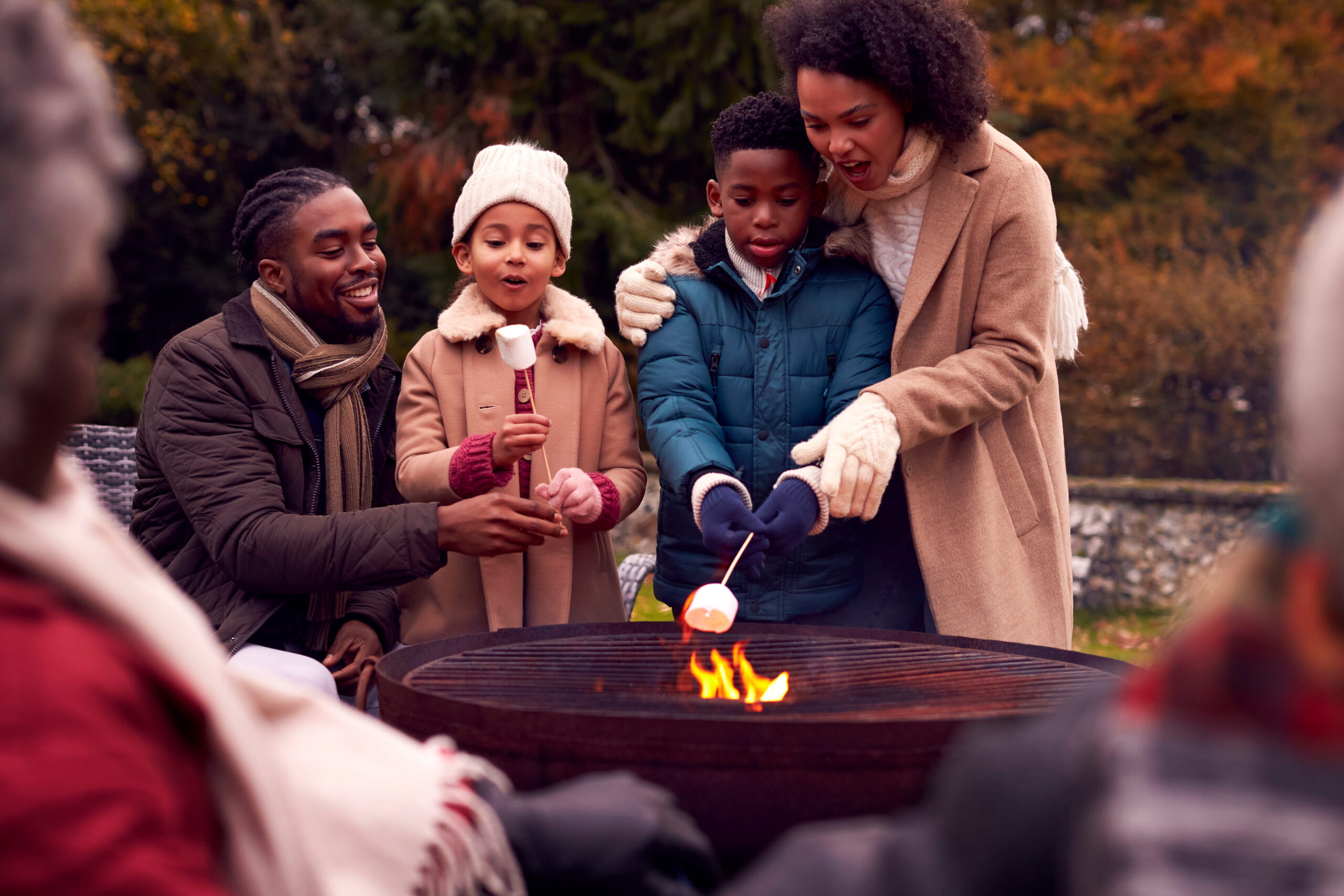 family roasting marshmallows over a fire pit family roasting marshmallows over a fire pit