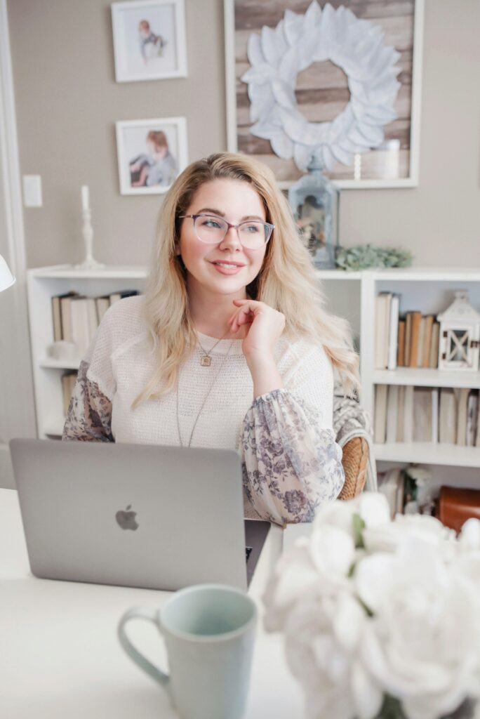 woman at a desk researching affiliate programs for bloggers, writing in a notebook next to her open laptop woman at a desk researching affiliate programs for bloggers, writing in a notebook next to her open laptop