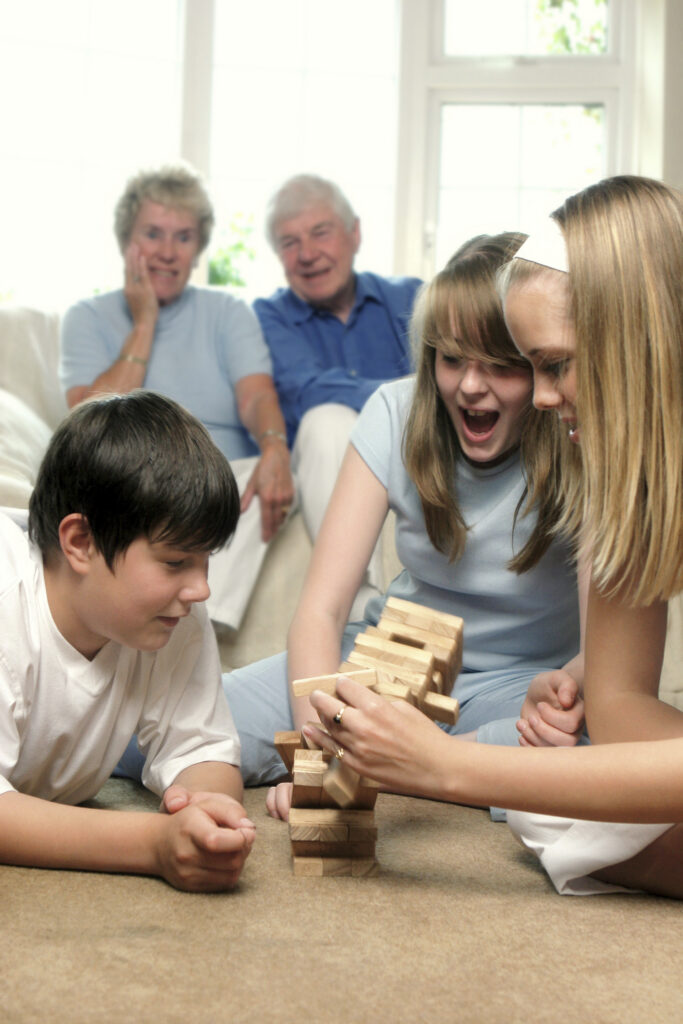 children playing Jenga with grandparents looking on children playing Jenga with grandparents looking on