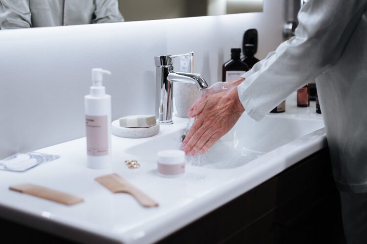 woman washing her hands in the bathroom sink woman washing her hands in the bathroom sink