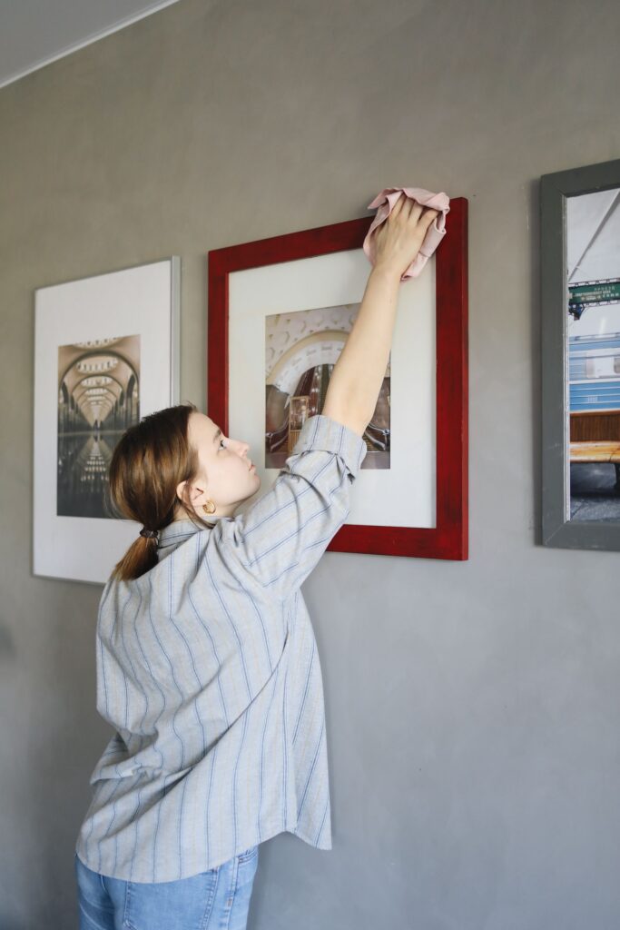 woman dusting photos on the wall woman dusting photos on the wall