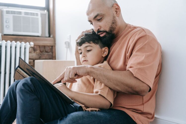 father reading a book to his son father reading a book to his son